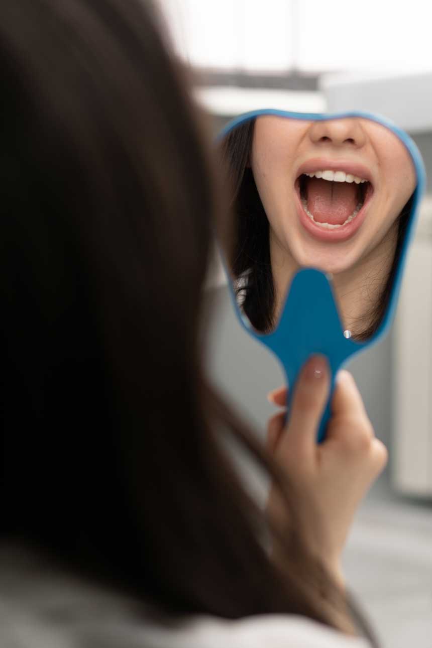 dentistry-a-satisfied-patient-looks-in-the-mirror-2023-12-27-15-53-33-utc
