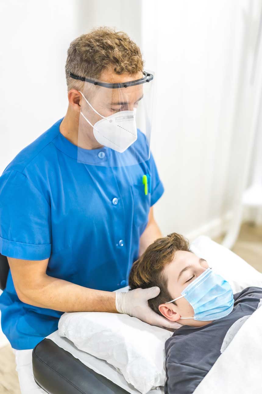 vertical-shot-of-a-physiotherapist-in-a-face-mask-2023-11-27-05-17-27-utc